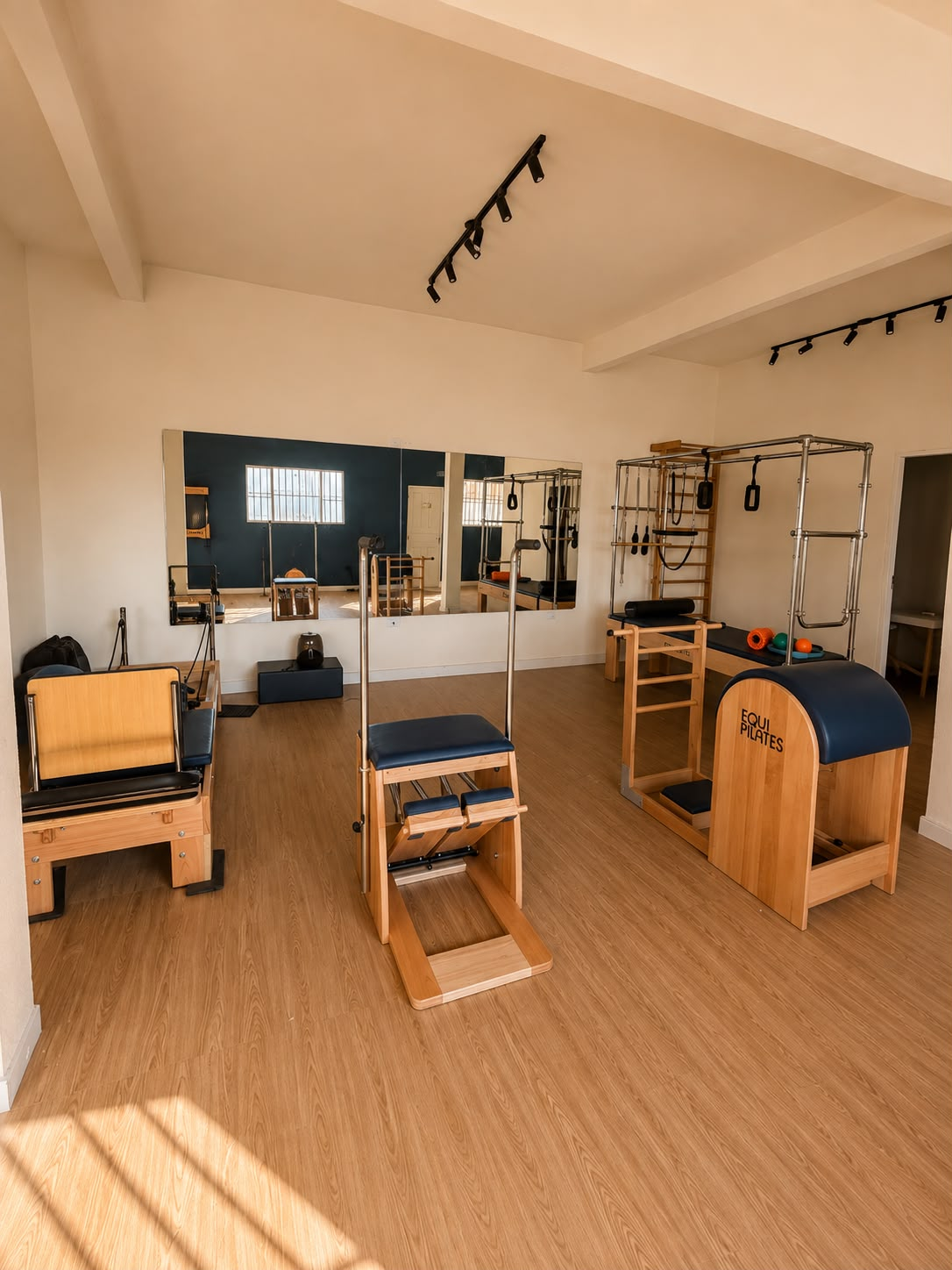 Sala ampla de Pilates da Áurea com Chair, Ladder Barrel, Reformers e parede espelhada